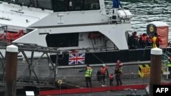 Migrant children picked up at sea attempting to cross the English Channel are helped from a vessel after arriving at the marina in Dover, southeast England, on June 12, 2024. More than 10,000 irregular migrants have crossed the Channel to Britain on small boats this year.