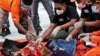 Investigators inspect debris found off Java Island around where a Sriwijaya Air passenger jet crashed, at Tanjung Priok Port in Jakarta, Indonesia, Jan. 10, 2021. 