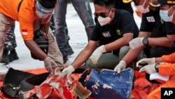 Investigators inspect debris found off Java Island around where a Sriwijaya Air passenger jet crashed, at Tanjung Priok Port in Jakarta, Indonesia, Jan. 10, 2021. 