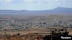 A tank belonging to the forces loyal to Syria's President Bashar al-Assad is seen in the Quneitra city countryside on Sept. 8, 2014 during a battle with rebels, near the border fence with Israeli-occupied Golan Heights.