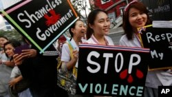 Para pekerja medis membawa poster memprotes pemerintah dalam demonstrasi di Bangkok (20/1). (AP/Wally Santana)