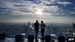 FILE — Two men stand on a terrace of the MahaNakhon building — now known as the King Power Mahanakhon — overlooking Bangkok's skyline, Nov. 11, 2020.