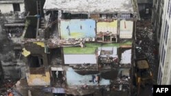 Petugas penyelamat mencari korban di puing-puing bangunan perumahan tiga lantai yang runtuh di Bhiwandi pada 21 September 2020 (Foto: AFP)