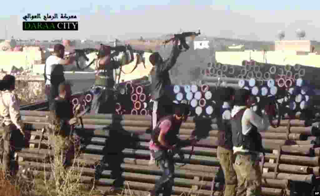 This image taken from video from the Sham News Network shows Syrian opposition fighters firing at government forces near Daraa, Sept. 25, 2013.