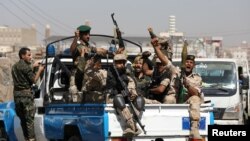 Tentara pemberontak Houthi menaiki truk patroli sambil meneriakkan slogan di Sanaa, Yaman. 