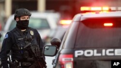 Police stand outside a King Soopers grocery store where a shooting took place March 22, 2021, in Boulder, Colo.
