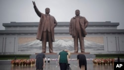 North Korean women bow to pay their respects to their late leaders Kim Il Sung and Kim Jong Il at Munsu Hill on Thursday, July 27, 2017, in Pyongyang, North Korea as part of celebrations for the 64th anniversary of the armistice that ended the Korean War. (AP Photo/Wong Maye-E)