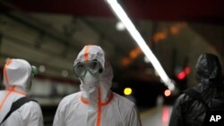 Para anggota Unit Gawat Darurat Militer menyemprotkan disinfektan di sebuah stasiun kereta bawah tanah untuk mencegah penyebaran Covid-19 di Madrid, Spanyol, 20 Maret 2020.