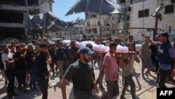 Palestinian mourners carry the bodies of relatives killed during an Israeli strike which hit a makeshift prayer hall at al-Shati refugee camp west of Gaza City on July 13, 2024 amid the ongoing conflict between Israel and the militant Hamas group in Gaza.