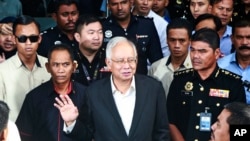 FILE - Former Malaysian Prime Minister Najib Razak, center, speaks to media as he leaves the Malaysian Anti-Corruption Commission (MACC) Office in Putrajaya, May 24, 2018. 