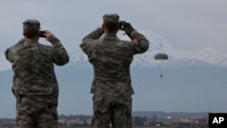 FILE - U.S Army soldiers of the 2nd Squadron, 38th Cavalry Regiment, part of the NATO-led peacekeeping mission in Kosovo watch fellow soldiers during a training exercise at U.S military base Camp Bondsteel, near the village of Sojeve in Kosovo, April 15, 2014.