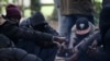 Des migrants soudanais attendent près d'un feu dans la forêt à Ouistreham, France, le 5 octobre 2017.
