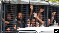Migrants ride on a truck as they are transferred from a temporary detention facility to a naval base on Langkawi island, Malaysia, on Wednesday, May 13, 2015.