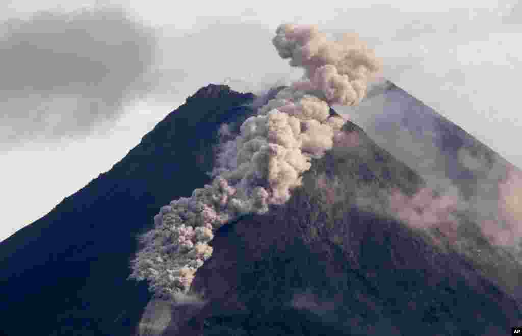 Awan panas dari abu vulkanik mengalir menuruni lereng Gunung Merapi saat terjadi letusan di Sleman, Yogyakarta hari Rabu, 27 Januari 2021.&nbsp;