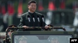 File - China's President Xi Jinping inspects the People's Liberation Army. Tanks, missile launchers and chanting troops greeted Xi in a potent display of Chinese military strength.