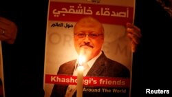 Un manifestant tient une affiche avec une photo du journaliste saoudien Jamal Khashoggi devant le consulat d'Arabie saoudite à Istanbul, en Turquie, le 25 octobre 2018.