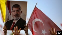 Pendukung mantan presiden Mesir Mohammed Morsi di Istanbul, Turki, 18 Juni 2019, mengacungkan poster Morsi saat mengikut salat mendoakan Morsi yang meninggal pada Senin (17/6).