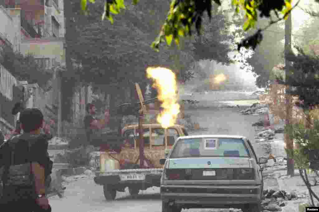 A member of the Free Syrian Army open fire from his machine gun during clashes with Syrian Army forces in Aleppo, September 27, 2012.