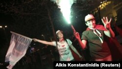 A man kneels in front of police blocking a march called by opposition political leader Juan Guaido in Caracas, Venezuela.