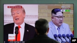 Seorang pria menyaksikan penayangan berita di layar televisi stasiun Seoul, Korea Selatan, 27 Maret 2018, yang menampilkan berita terkait Presiden AS Donald Trump (kiri) dan Pemimpin Korea Selatan Kim Jong-un (kanan). (Foto: dok).