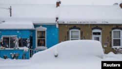 A car is snowed in during a snowstorm, in Hamilton, Ontario, Canada, Jan. 17, 2022.
