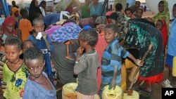 Women and children crowd around the public water taps at the Dollo Ado refugee transit facility in Ethiopia, October 26, 2011. (VOA - P. Heinlein)