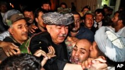 FILE - General Abdul Rashid Dostum, center in gray turban, leader of Afghanistan's Uzbek community returns to Kabul from exile, Aug. 16, 2009. 