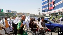 فروش پرچم‌های طالبان در هرات. سربرآوردن طالبان در افغانستان برای چین، روسیه و ایران، چالش‌های امنیتی، اقتصادی و اجتماعی به همراه دارد -- عکس آرشیو