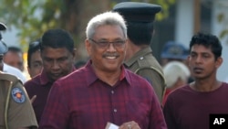 Sri Lanka's former defense secretary Gotabaya Rajapaksa, center, leaves a polling station after casting his vote in Embuldeniya, on the outskirts of Colombo, Sri Lanka, Nov. 16, 2019. 