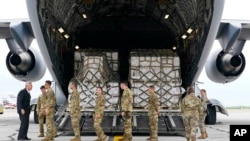 Menteri Pertanian AS Tom Vilsack menyambut awak militer AS yang baru tiba dari Jerman di bandara Indianapolis, India Minggu (22/5). Pesawat Hercules C-17 ini mengangkut susu formula bayi yang sedang langka di toko-toko AS.