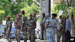 Ivorian soldiers stand guard at the entrance to electoral commission headquarters in Abidjan.