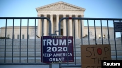 Pendukung Presiden AS Donald Trump menggantungkan tulisan di luar gedung Mahkamah Agung AS di Washington, AS, 10 November 2020. (Foto: REUTERS/Hannah McKay)
