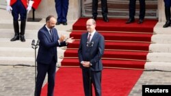 Mantan Perdana Menteri Perancis Edouard Philippe (kiri) bertepuk tangan untuk Jean Castex yang baru saja ditunjuk menjadi Perdana Menteri Perancis yang baru, di Hotel Matignon, Paris, 3 Juli 2020. 