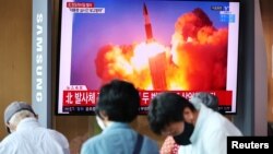 韩国首尔民众在观看电视新闻播放朝鲜试射两枚洲际弹道导弹的报道。（2021年9月15日）