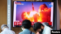  People watch a TV broadcasting file footage of a news report on North Korea firing what appeared to be a pair of ballistic missiles off its east coast, in Seoul, South Korea, September 15, 2021.