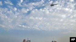 FILE - A speedboat and a helicopter of the Iran's Revolutionary Guard move around a British-flagged oil tanker Stena Impero, which was seized by the Guard, in the Iranian port of Bandar Abbas, July 21, 2019. 