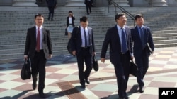 Anggota delegasi Perdagangan China berjalan meninggalkan gedung Departemen Keuangan AS setelah melangsungkan pembicaraan selama dua hari dengan perwakilan AS di Washington DC, 23 Agustus 2018.