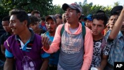 A Honduran migrant stands in line for breakfast at a temporary shelter in Tecun Uman, Guatemala, at the border with Mexico, Jan. 19, 2020.