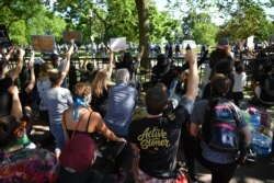 Protestors take a knee and raise their fists in Lafayette Square near the White House in Washington, DC on June 1, 2020.