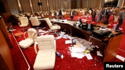 Men inspect Libya's General National Congress (GNC) building a day after protesters stormed into the building in Tripoli, March 3, 2014.