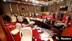 Men inspect Libya's General National Congress (GNC) building a day after protesters stormed into the building in Tripoli, March 3, 2014.