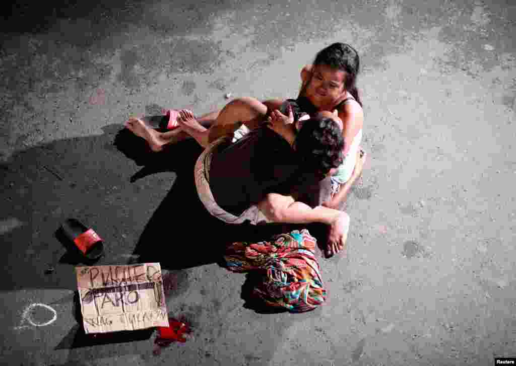 A woman cradles the body of her husband who was killed on a street by a vigilante group, according to police, in a spate of drug related killings in Pasay city, Metro Manila, Philippines, July 23, 2016.