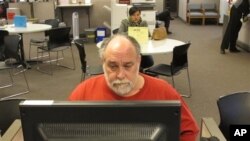 FILE - Richard Mattos, 59, looks for jobs at state-run employment center in Salem, Oregon.