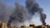 ফাইল: সুদানের খার্তুমে উত্তরাঞ্চলে আধাসামরিক বাহিনী র‍্যাপিড সাপোর্ট ফোর্সেস এবং সেনাবাহিনীর মধ্যে সংঘর্ষের সময় বিমান হামলার পর ভবনগুলোর ওপরে ধোঁয়া উড়ছে এবং একজন ব্যক্তি হেঁটে যাচ্ছেন । ১ মে, ২০২৩। ফাইল ছবি। 
