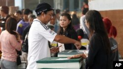A local resident casts his ballot for the general election at a polling station in Bangkok, Feb. 2, 2014.