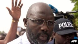 George Weah s'adresse aux journalistes après avoir voté pour le second tour des élections présidentielles le 26 décembre 2017 dans un bureau de vote à Monrovia.