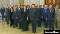 북한이 지난해 처형한 장성택의 부인이자 김정은 국방위원회 제1위원장의 고모인 김경희 당 비서의 모습을 기록영화에서 삭제했다. 사진은 김 비서(위 붉은 원안)의 모습이 포함돼 있던 지난해 12월 13일 기록영화 첫 방송분. (자료사진)