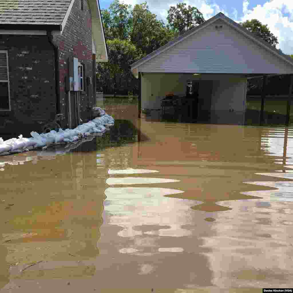 Sandbags are used to keep floodwaters away from the Kinchen family's home, in of St. Amant, La., Aug. 18, 2016.