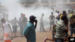Opposition protesters disperse after tear gas is fired in their midst, in Conakry, Guinea, February 27, 2013. 