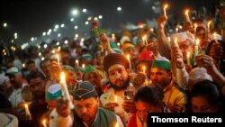 Farmers participate in a candlelight vigil to pay homage to paramilitary troops killed in a suicide bomb attack in south Kashmir's Pulwama district in 2019, in Ghaziabad, India, Feb. 14, 2021.